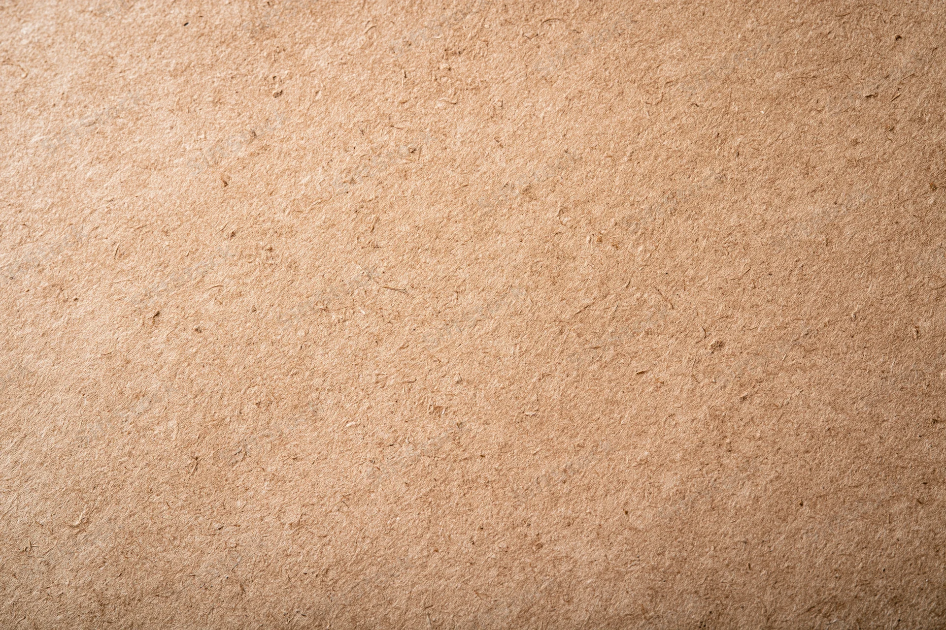 Close-up flat lay of a smooth kraft paper surface with visible texture and natural fiber grain