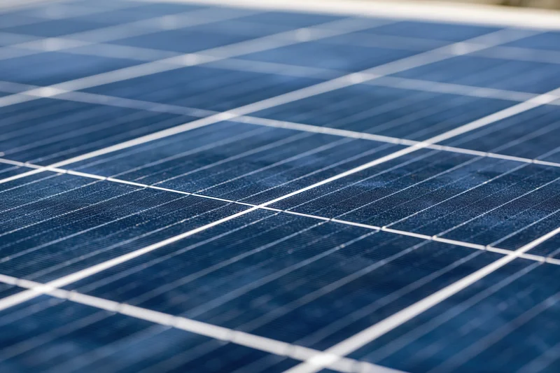 Close-up of solar panel surface showing grid of photovoltaic cells under daylight