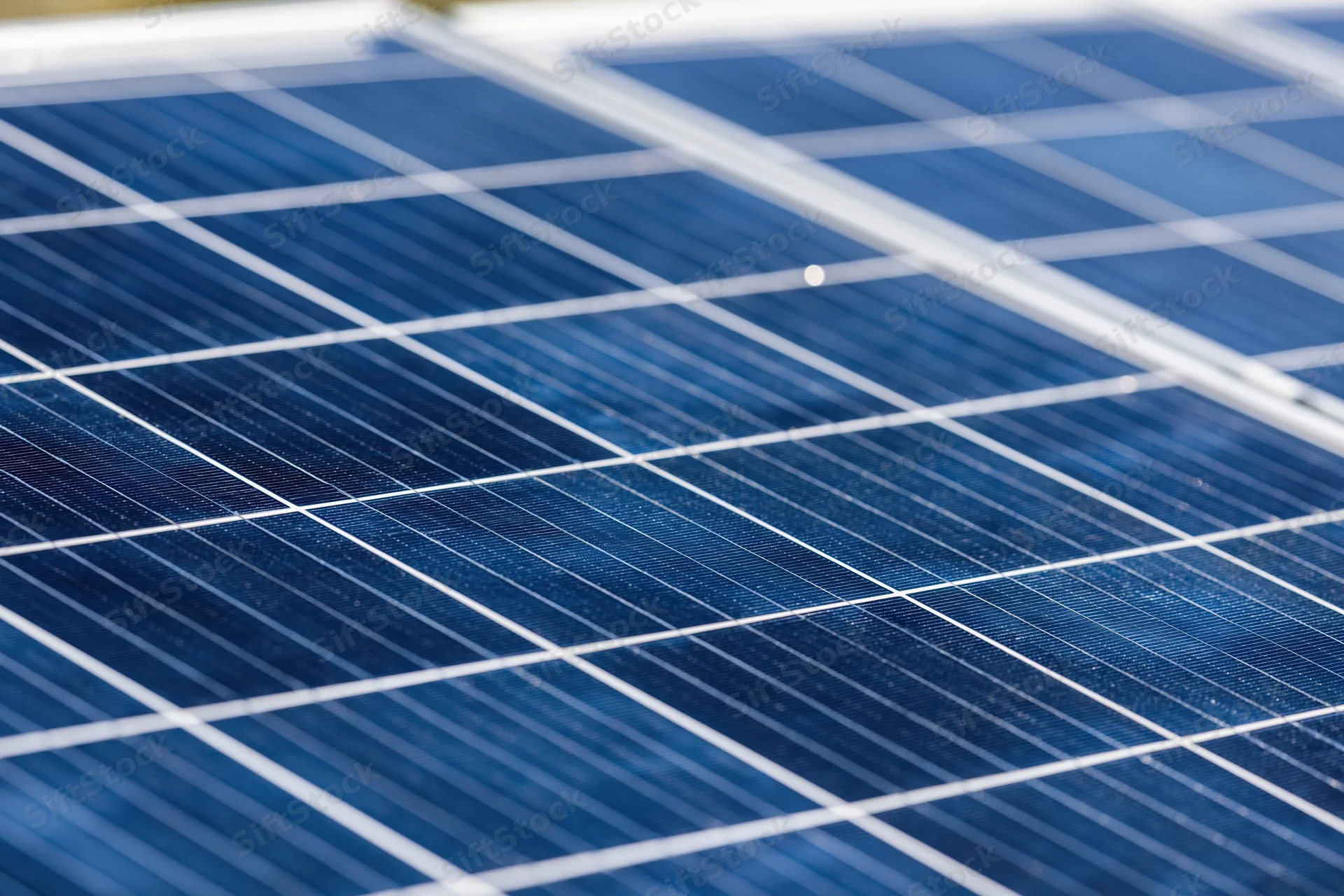 Close-up of solar panel surface showing blue photovoltaic cells and white gridlines