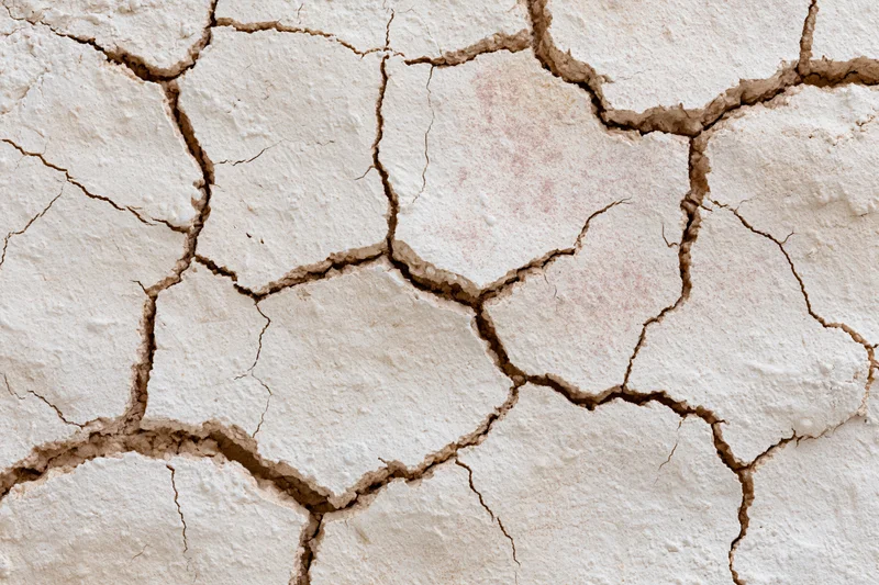 Cracked dried plaster surface in close-up macro view
