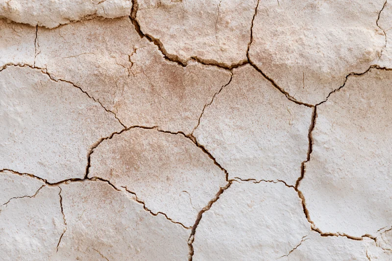 Cracked dried plaster surface in close-up macro view