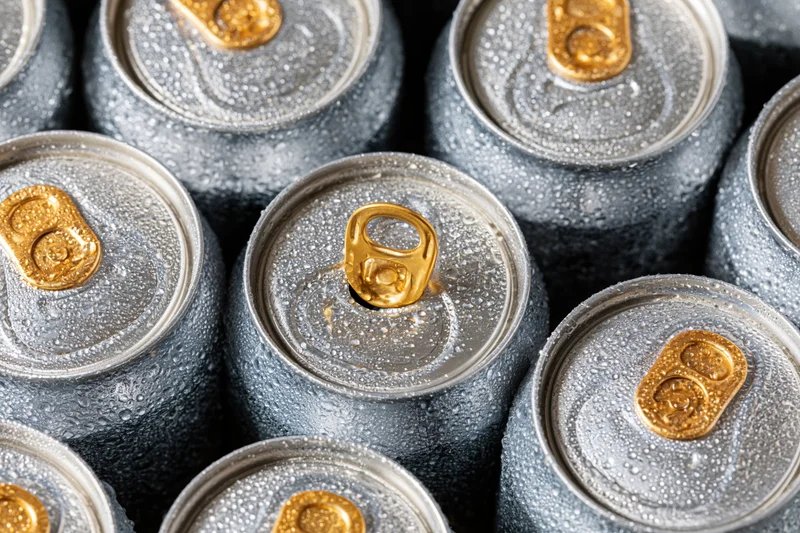 Chilled aluminum beverage cans with condensation arranged in a close-up overhead cluster