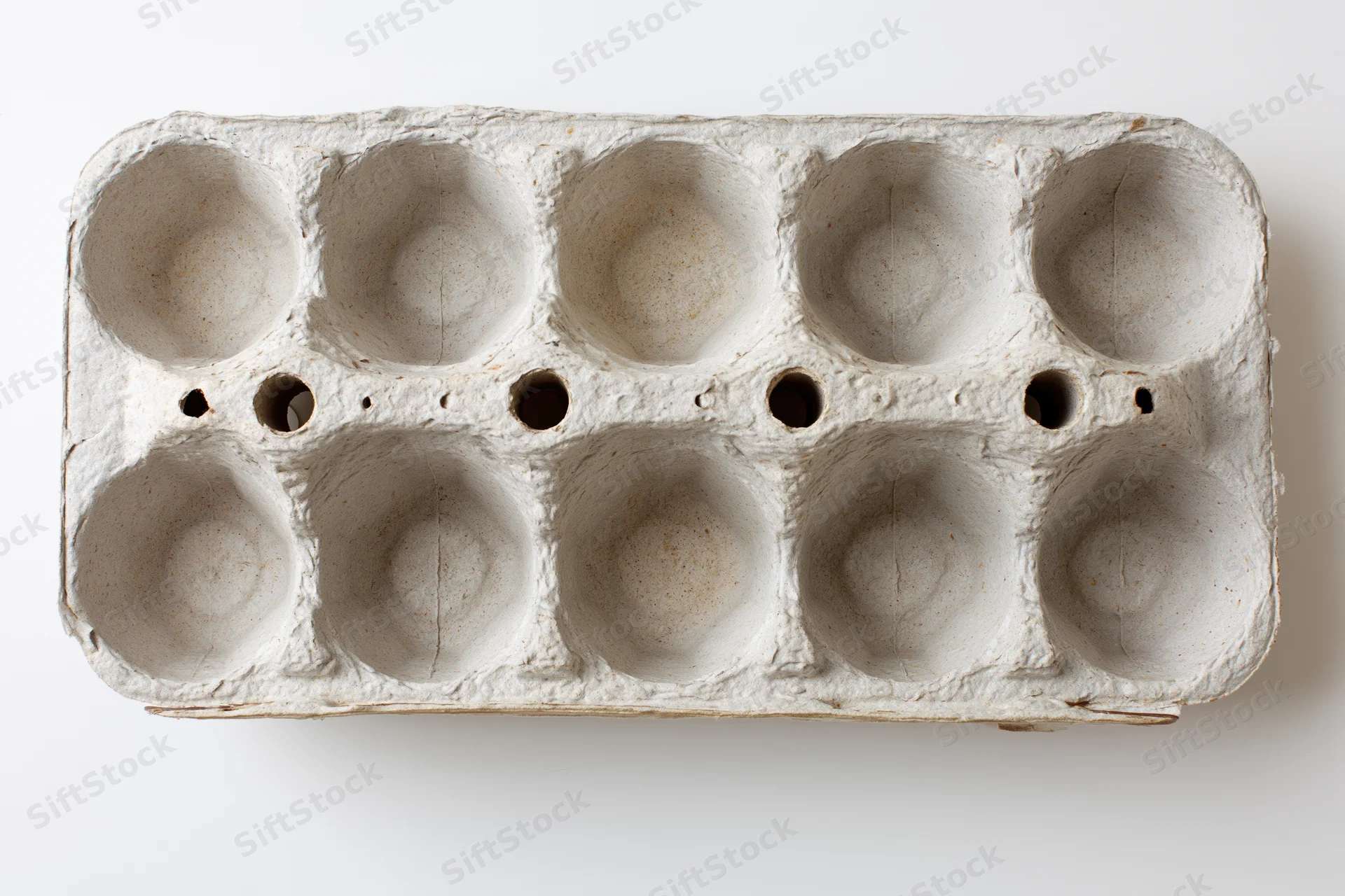 Empty twelve-cup recycled cardboard egg carton lying open on white surface