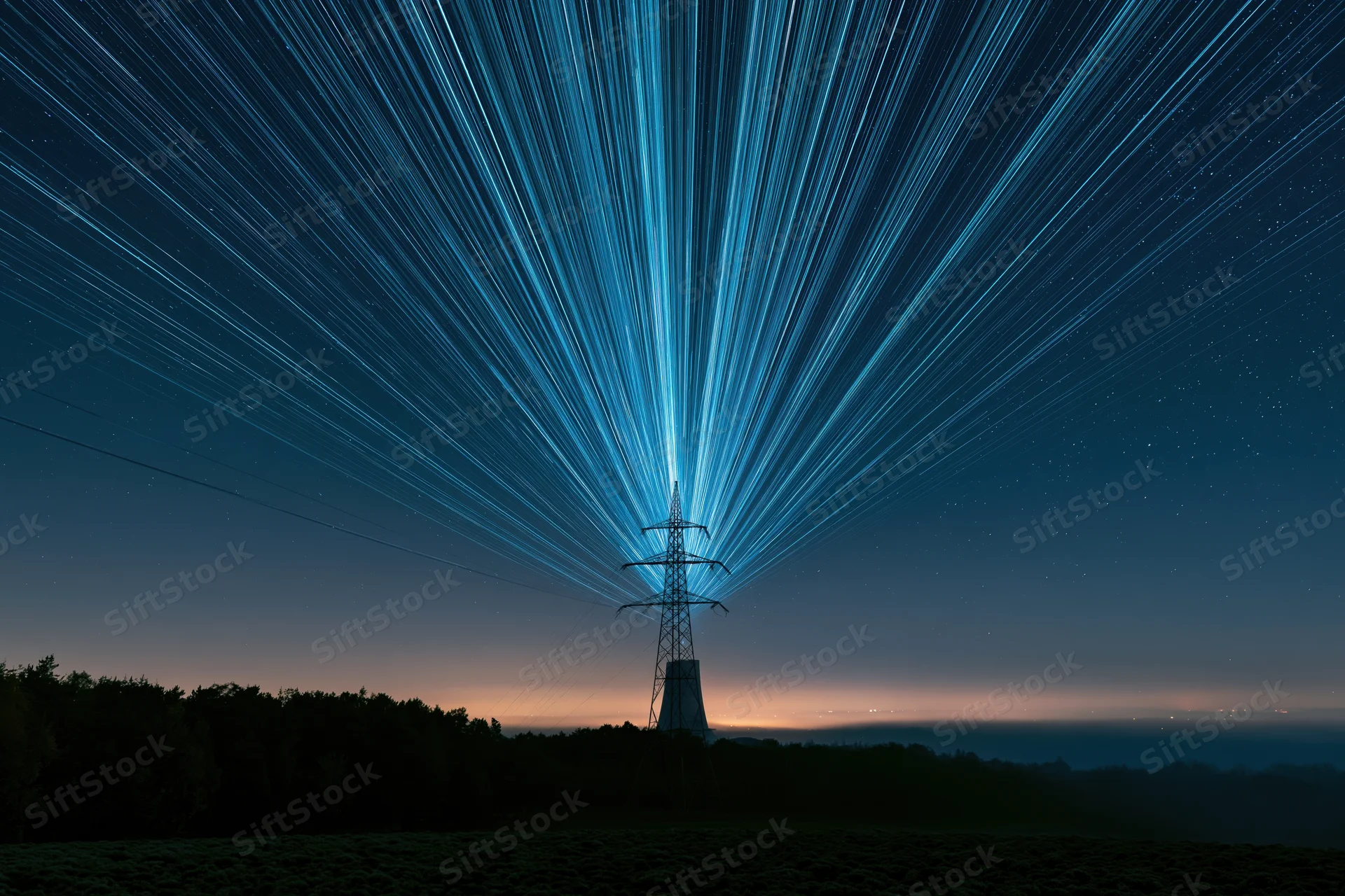 High-voltage transmission tower silhouetted against star trails in a rural night landscape
