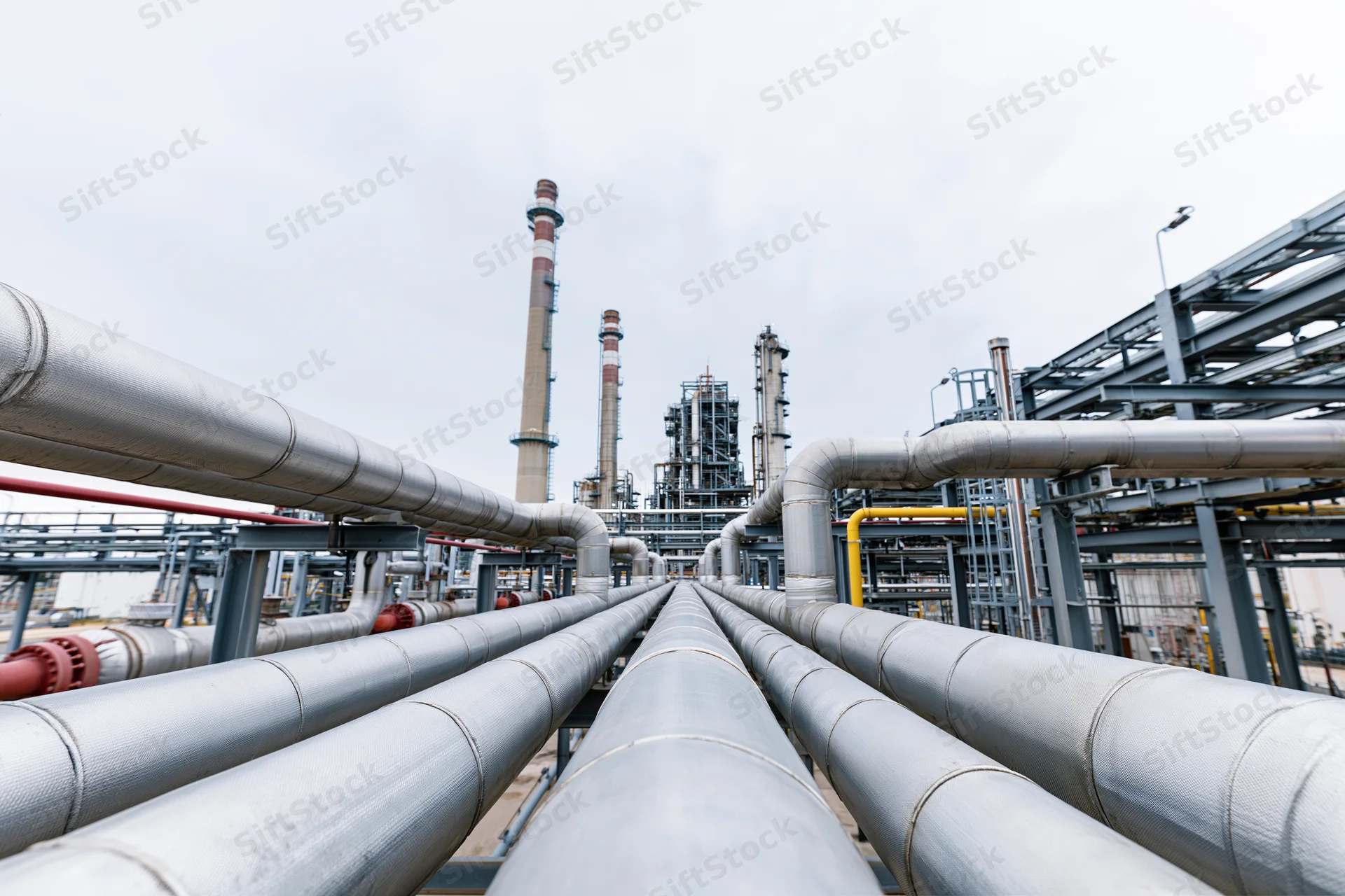 Insulated steel pipelines running through an industrial refinery complex
