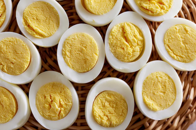 Hardboiled egg halves arranged cut-side up in a wicker basket