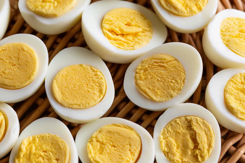 Hard-boiled egg halves arranged cut-side up on a woven basket surface