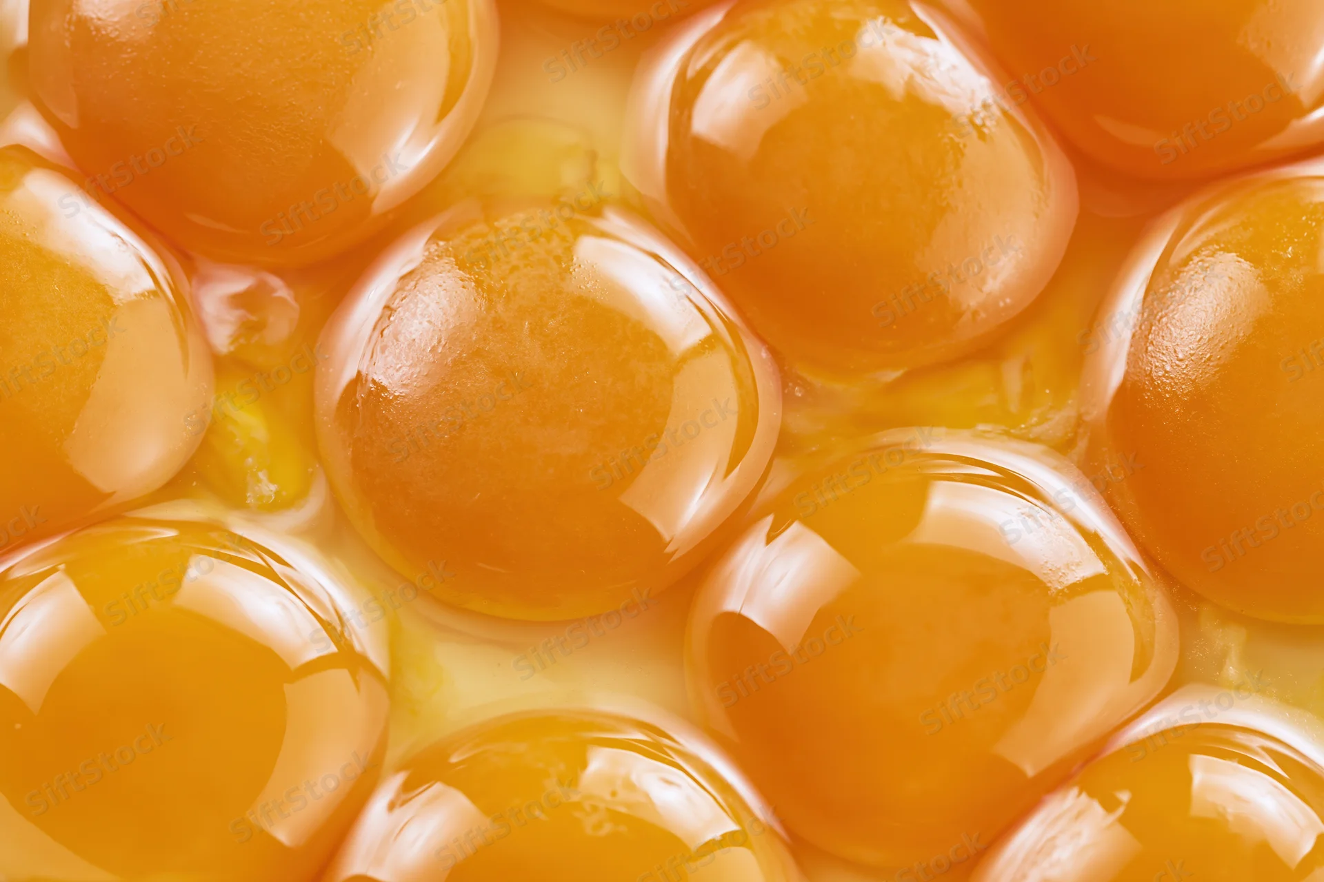 Multiple raw egg yolks closely packed in a bowl