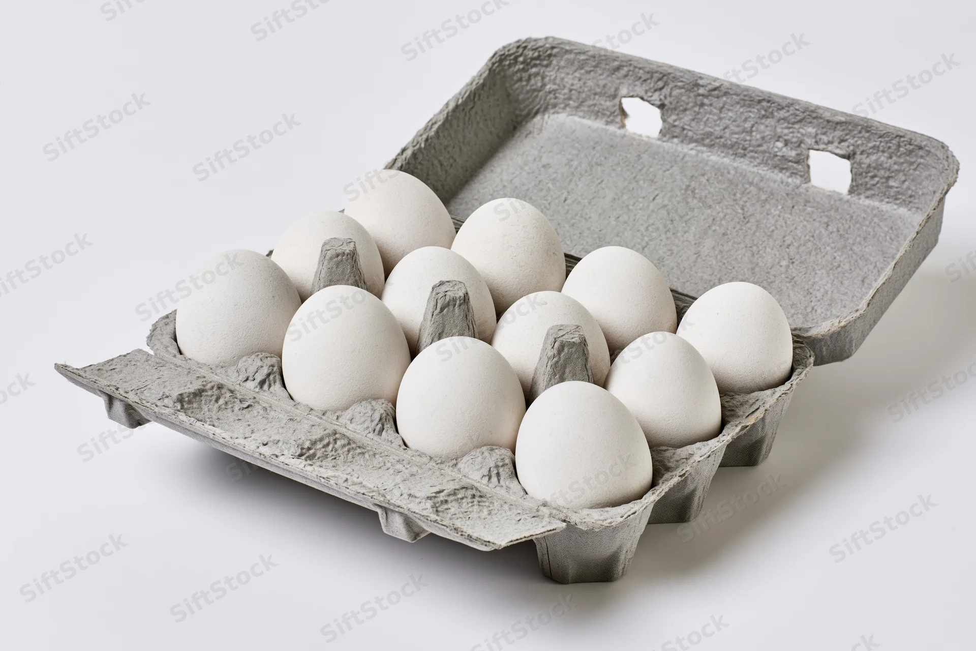 Open gray recycled cardboard egg carton holding ten white eggs on white background