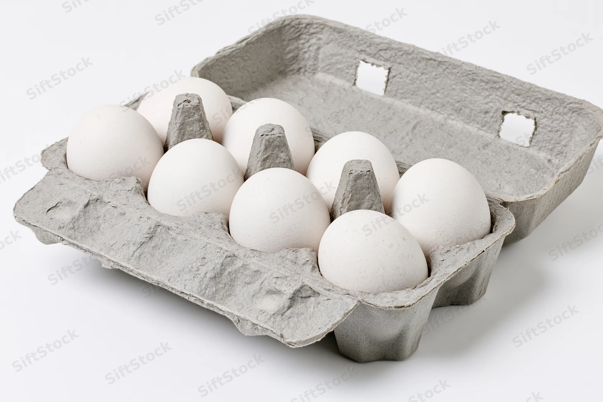 Open gray recycled cardboard egg carton holding ten white eggs on white background
