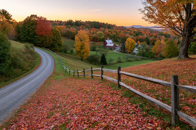 Rural Vermont hillside farm in peak autumn viewed from a slope
