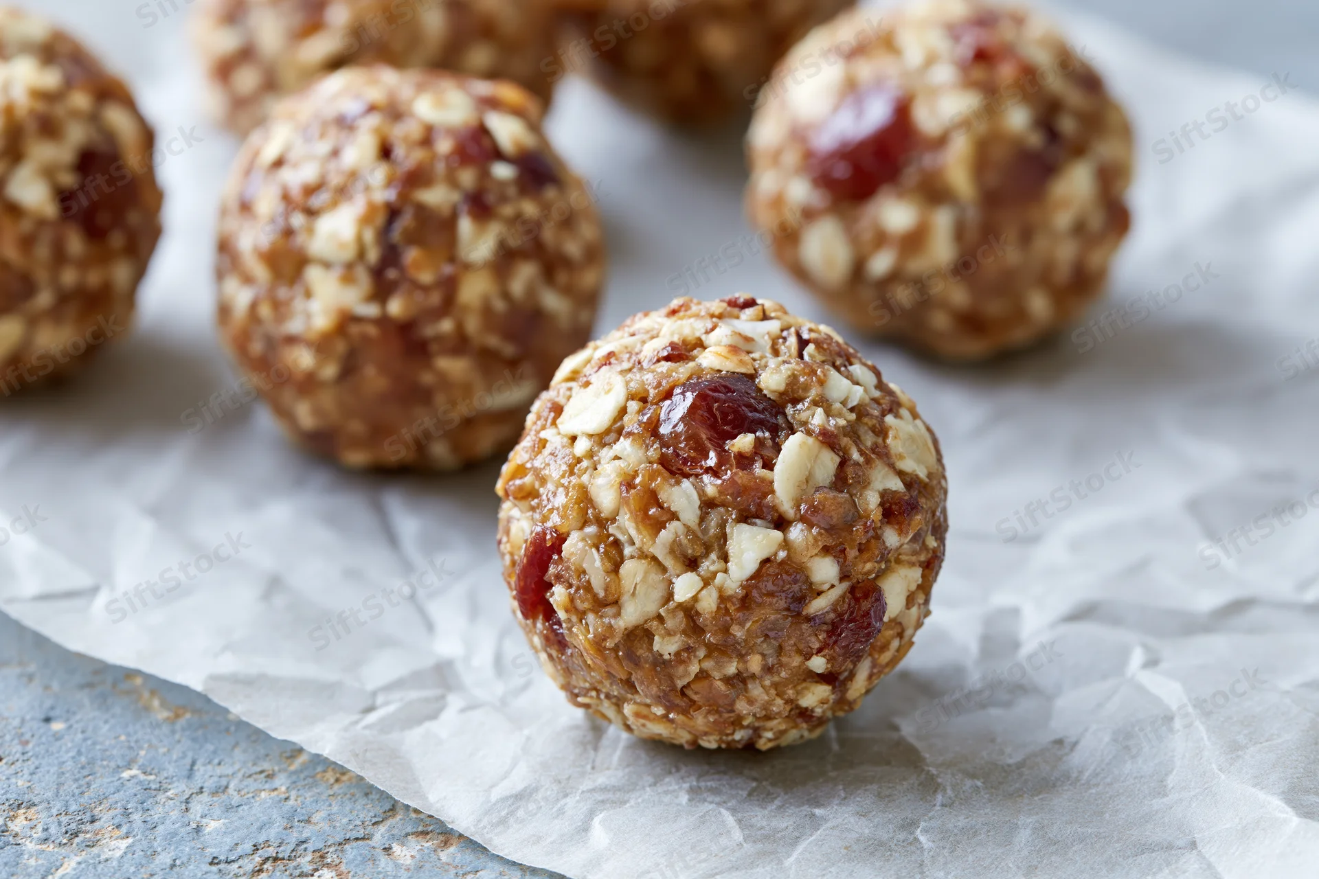 No-bake oat and date energy balls arranged on crumpled parchment paper