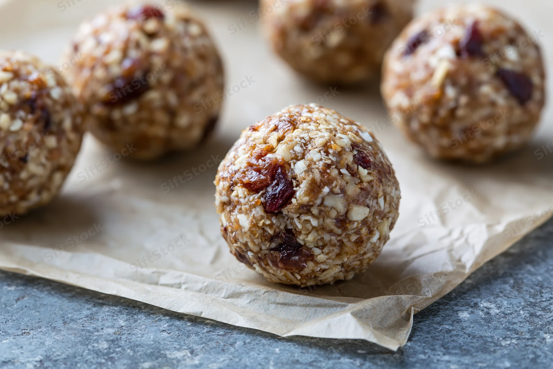 No-bake oat and date energy balls arranged on crumpled parchment paper
