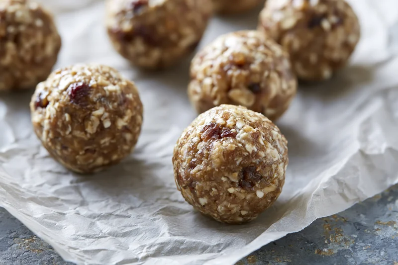 No-bake oat and date energy balls arranged on crumpled parchment paper