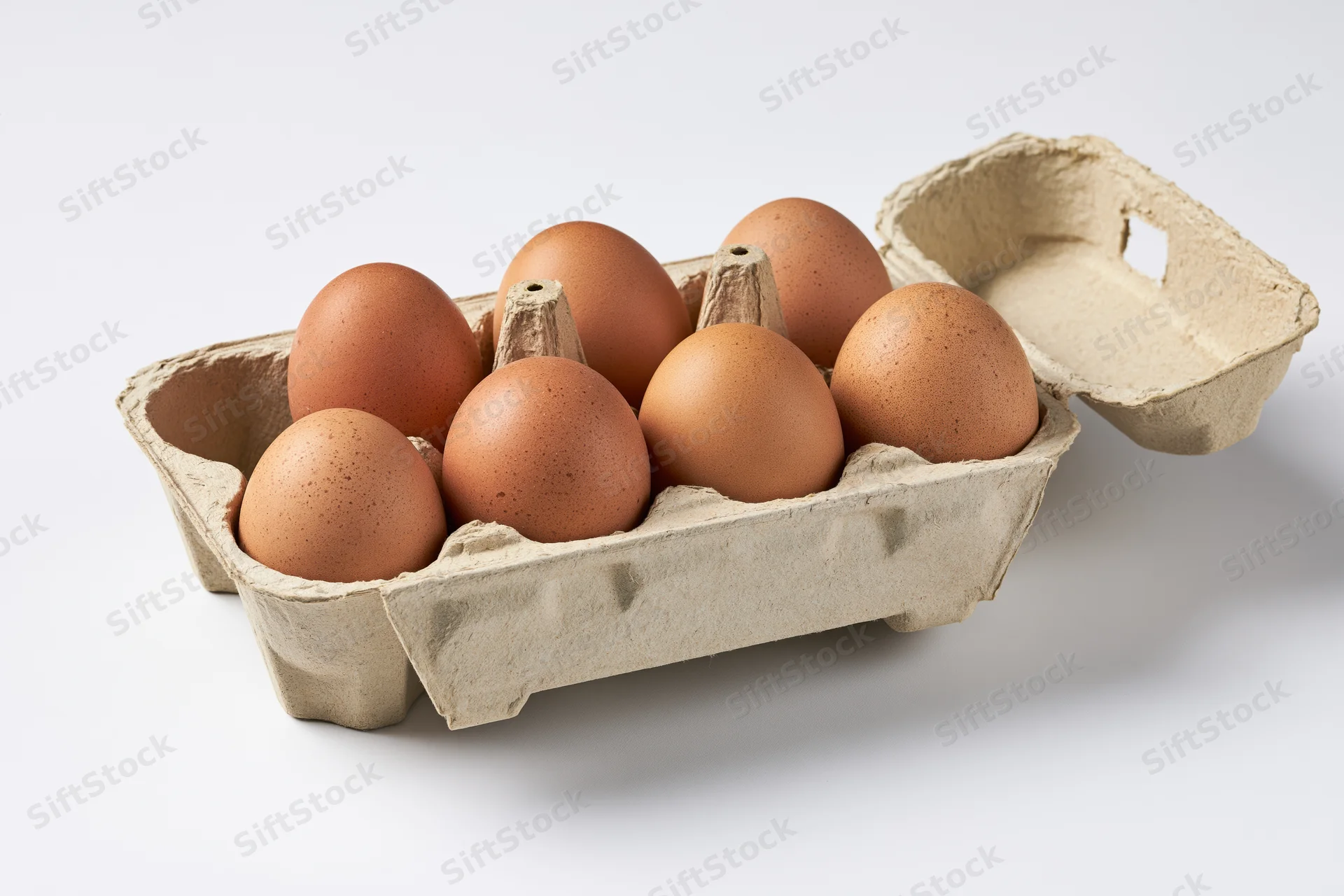 Six brown chicken eggs in an open cardboard carton on a white surface
