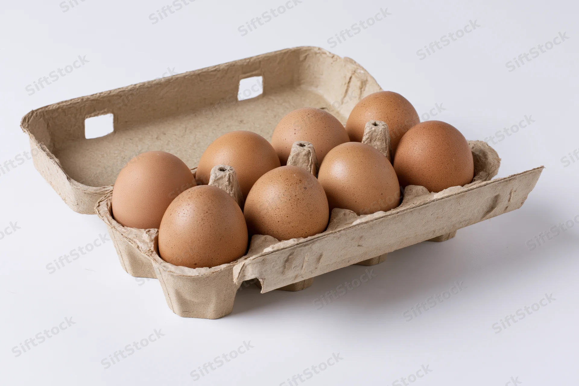 Six brown chicken eggs arranged in an open cardboard carton on a white surface