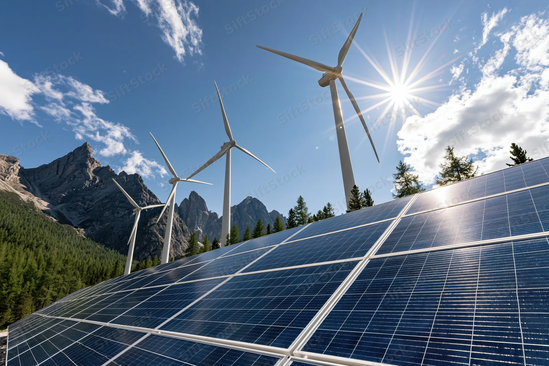 Solar panels in foreground with wind turbines on mountain landscape under bright sun