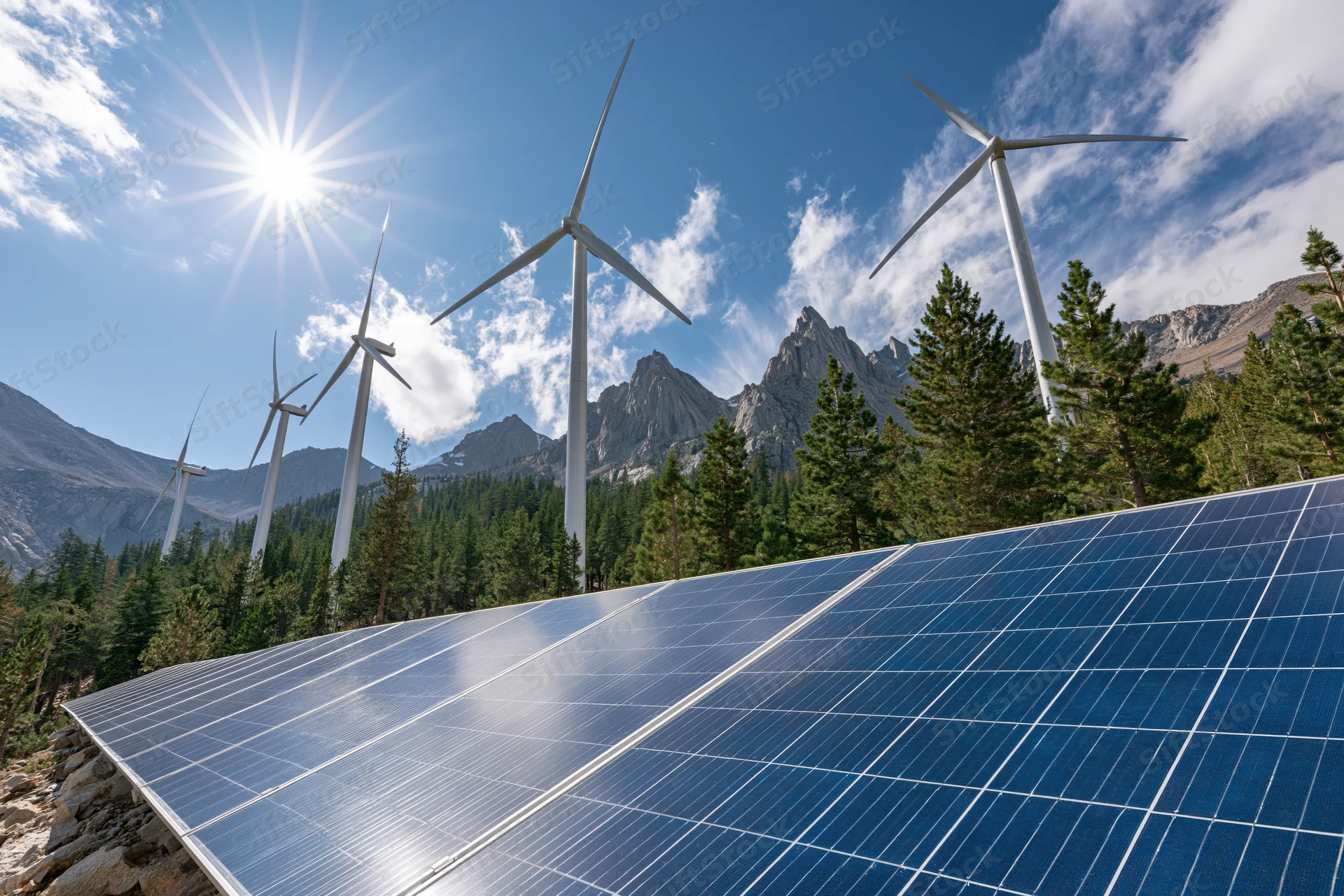 Solar panel array in foreground with wind turbines behind in mountain forest landscape
