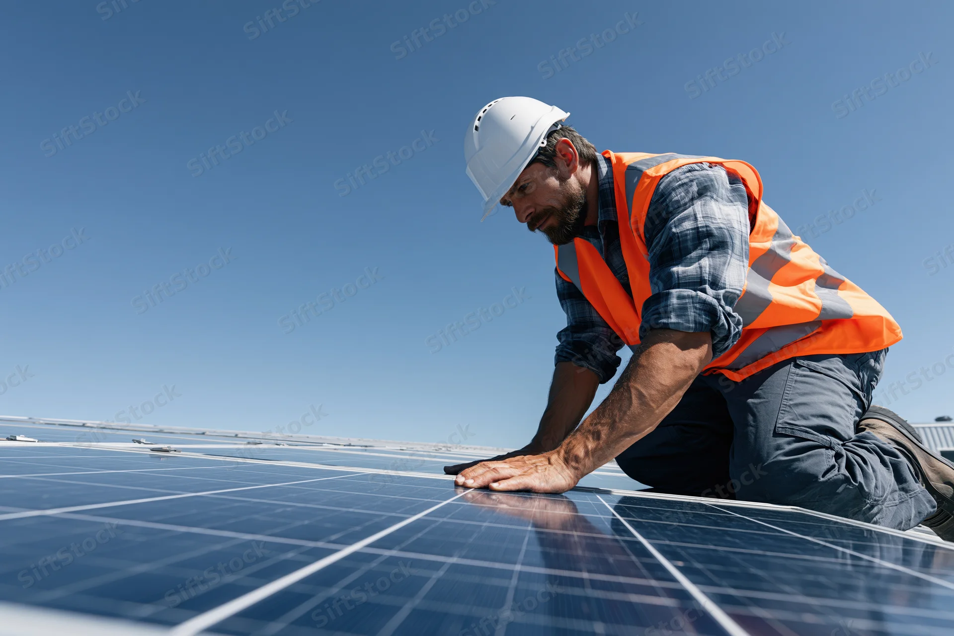Technician inspecting solar panel on rooftop under clear sky