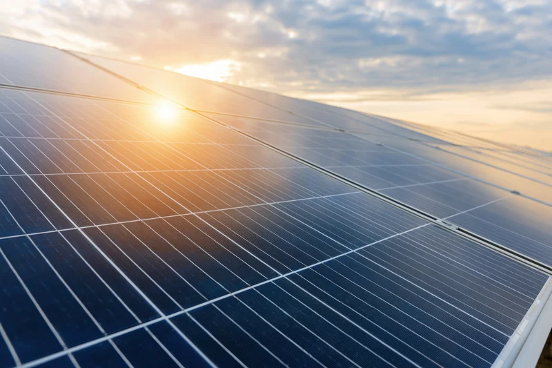 Solar panels angled toward the sky at sunset, capturing sunlight for energy generation