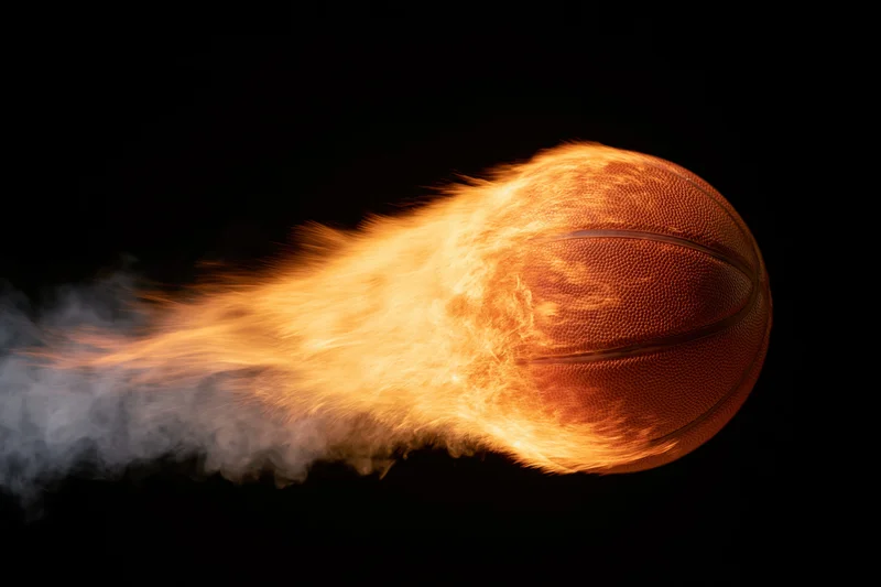 Basketball engulfed in flames streaking across black background