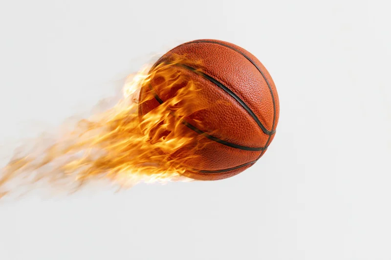 Basketball engulfed in flames streaking through the air against a white background