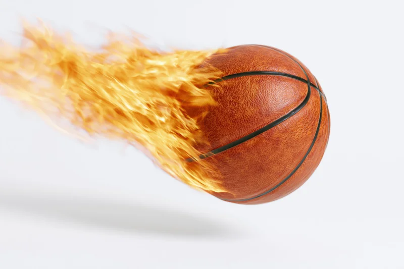 Flaming basketball in motion against white background