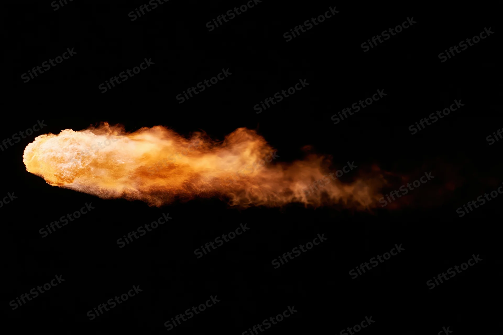 Horizontal jet of fire and flame streaking across a pure black background