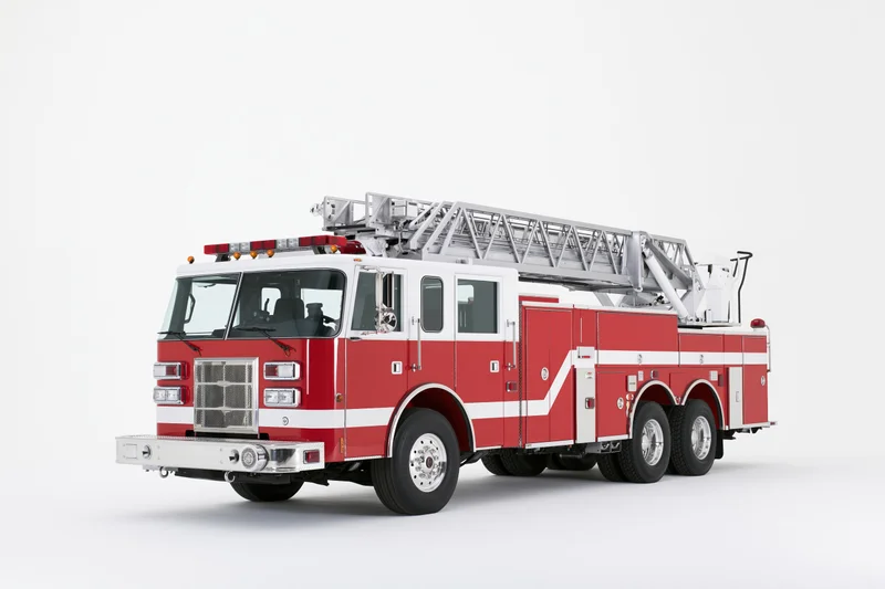 Red and white american ladder fire truck parked stationary on white background