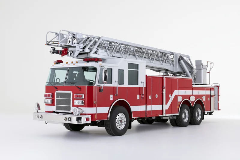 Red and white american ladder fire truck parked stationary on white background