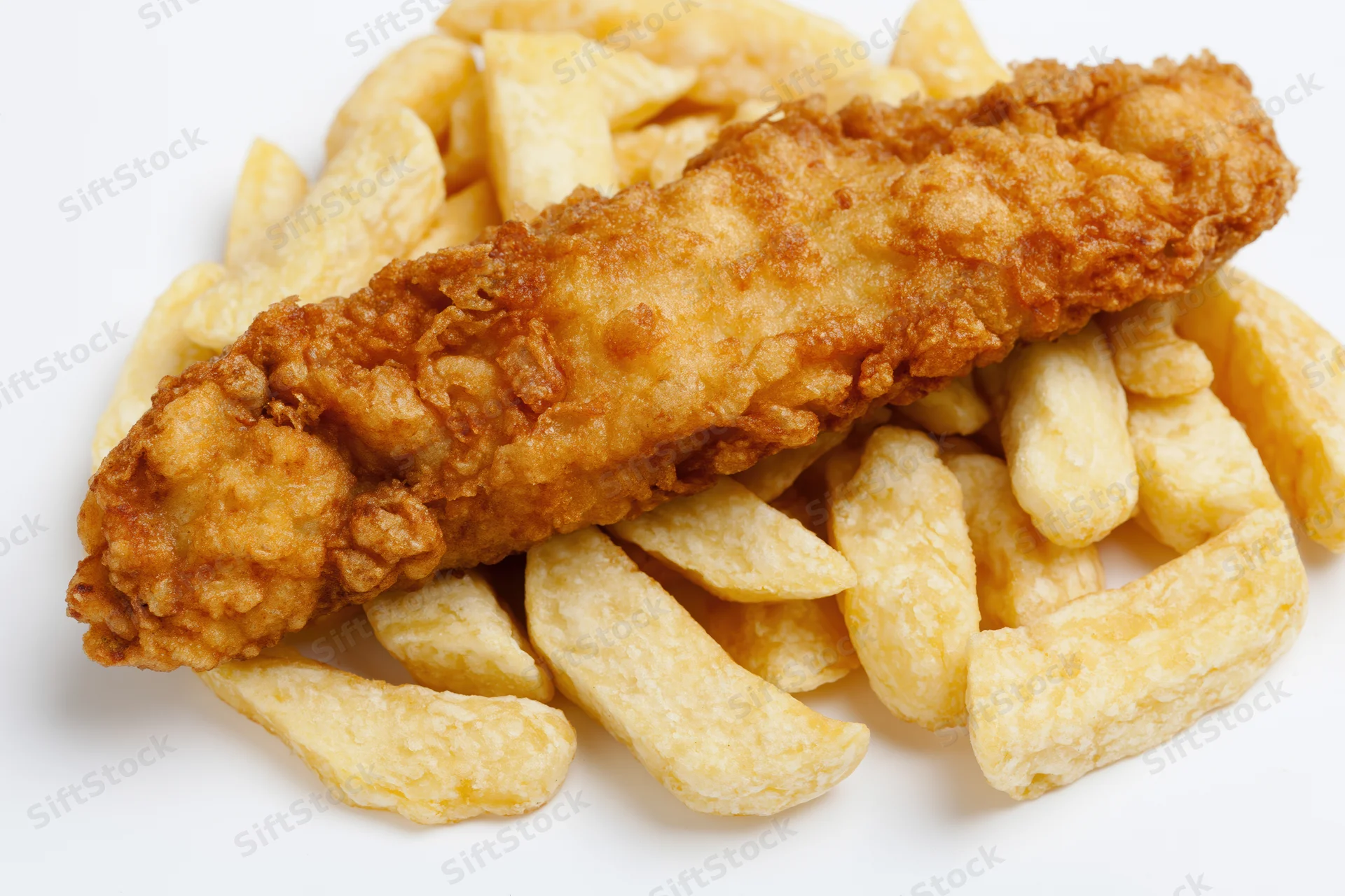 Battered fish fillet resting on thick-cut chips against white background