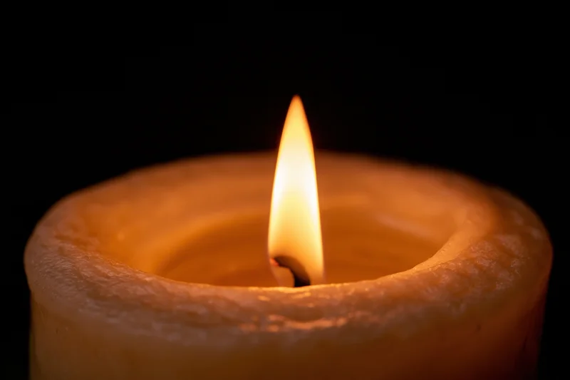 A single candle flame burning steadily against a dark background