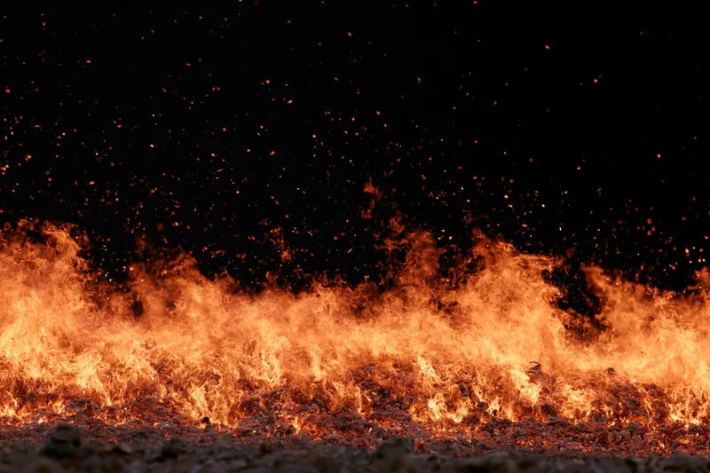 Intense wall of flames rising from ground at night