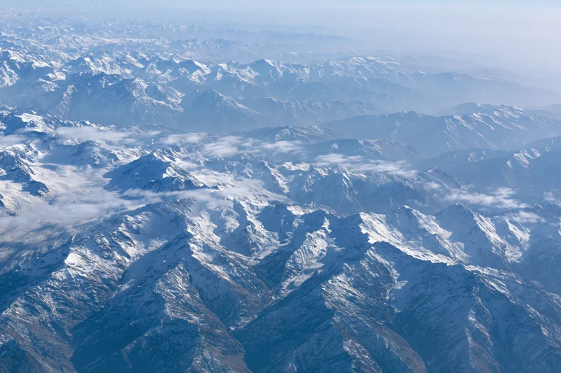 Aerial view of snow-covered mountain ranges stretching into the distance