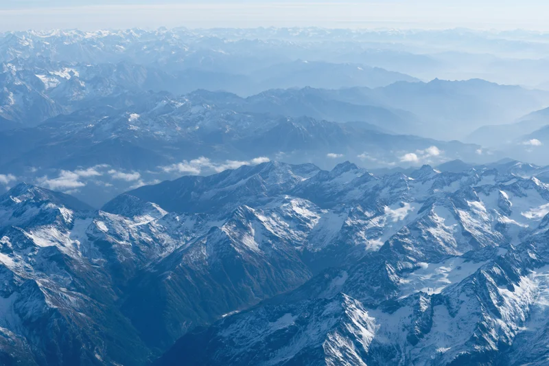 Aerial view of snow-capped mountain ranges stretching into the distance