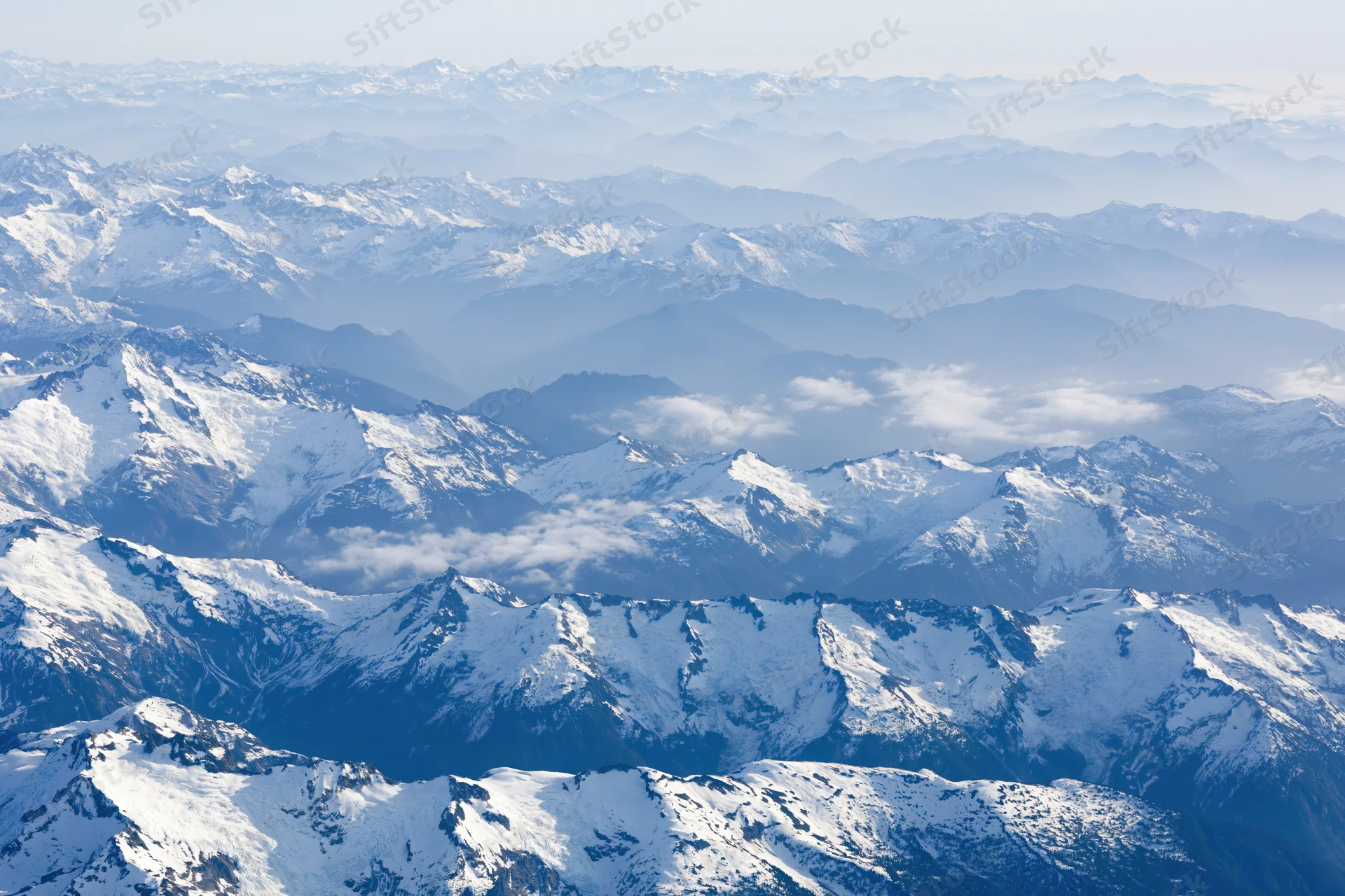 Aerial view of snow-covered mountain ranges stretching into the distance
