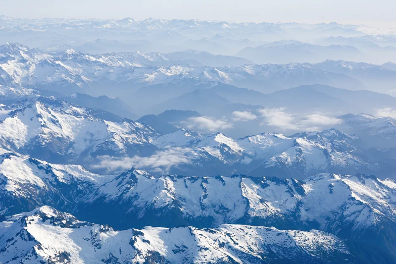 Aerial view of snow-covered mountain ranges stretching into the distance