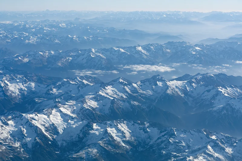 Aerial view of snow-covered mountain ranges stretching into the distance