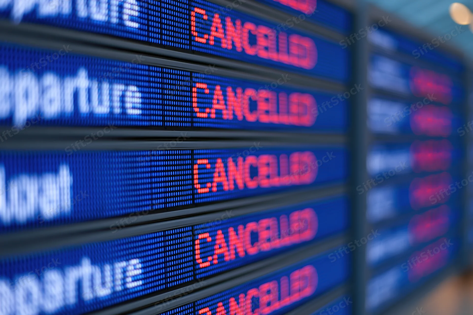Digital flight information board showing multiple cancelled departures at airport terminal