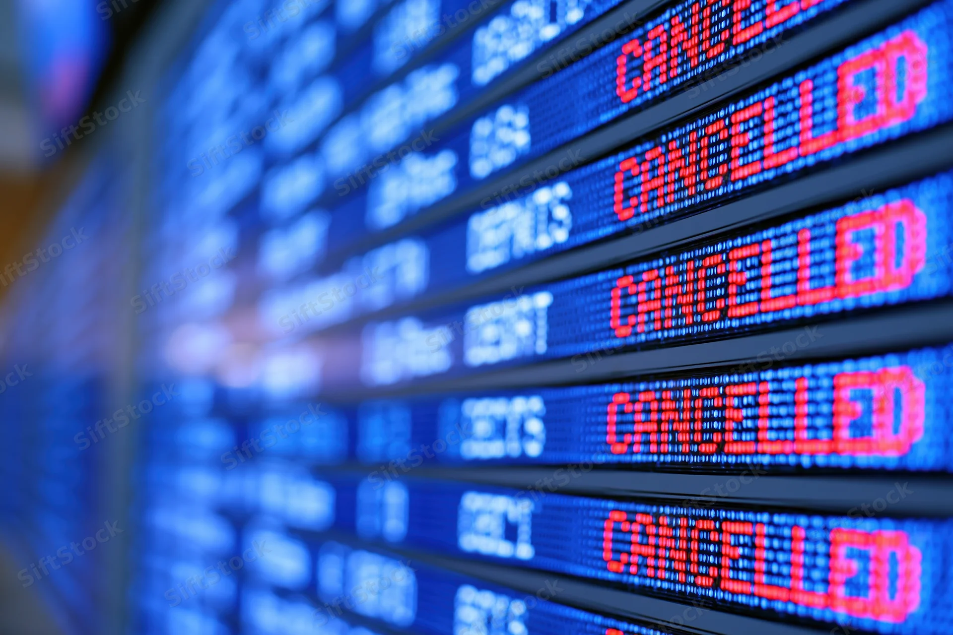 Digital flight information board showing multiple cancelled departures at airport terminal