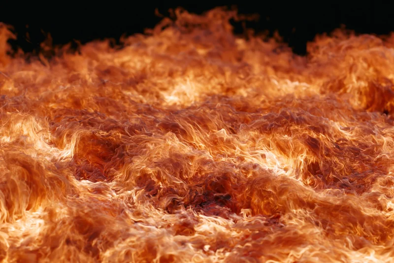 Roaring fire with churning flames filling the frame against black background