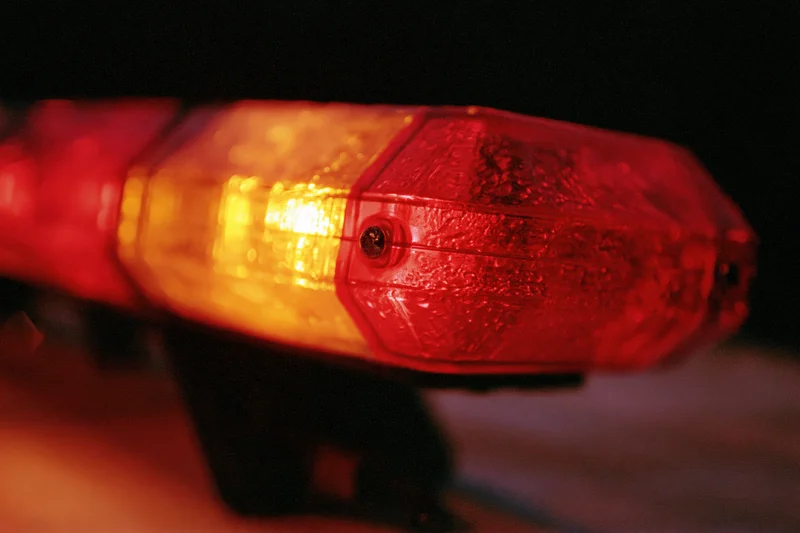 Close-up of red and amber emergency vehicle light bar flashing at night