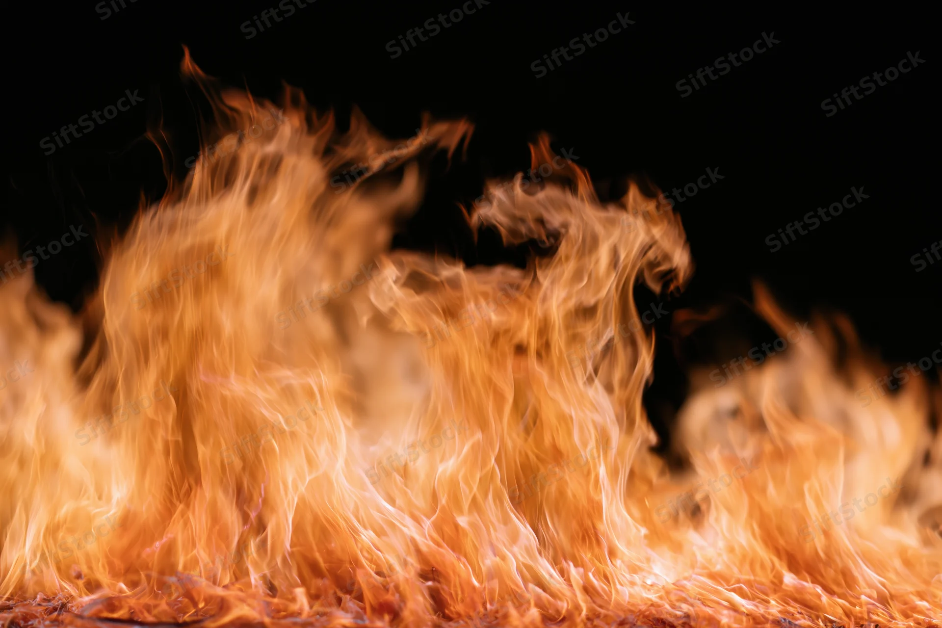 Tall flames rising against a black background