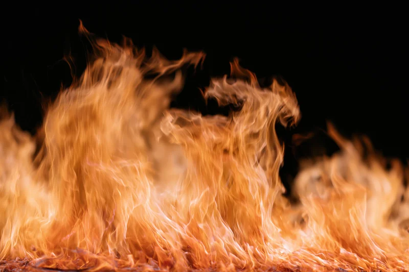 Tall flames rising against a black background