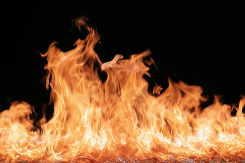 Tall flames burning intensely against a pure black background