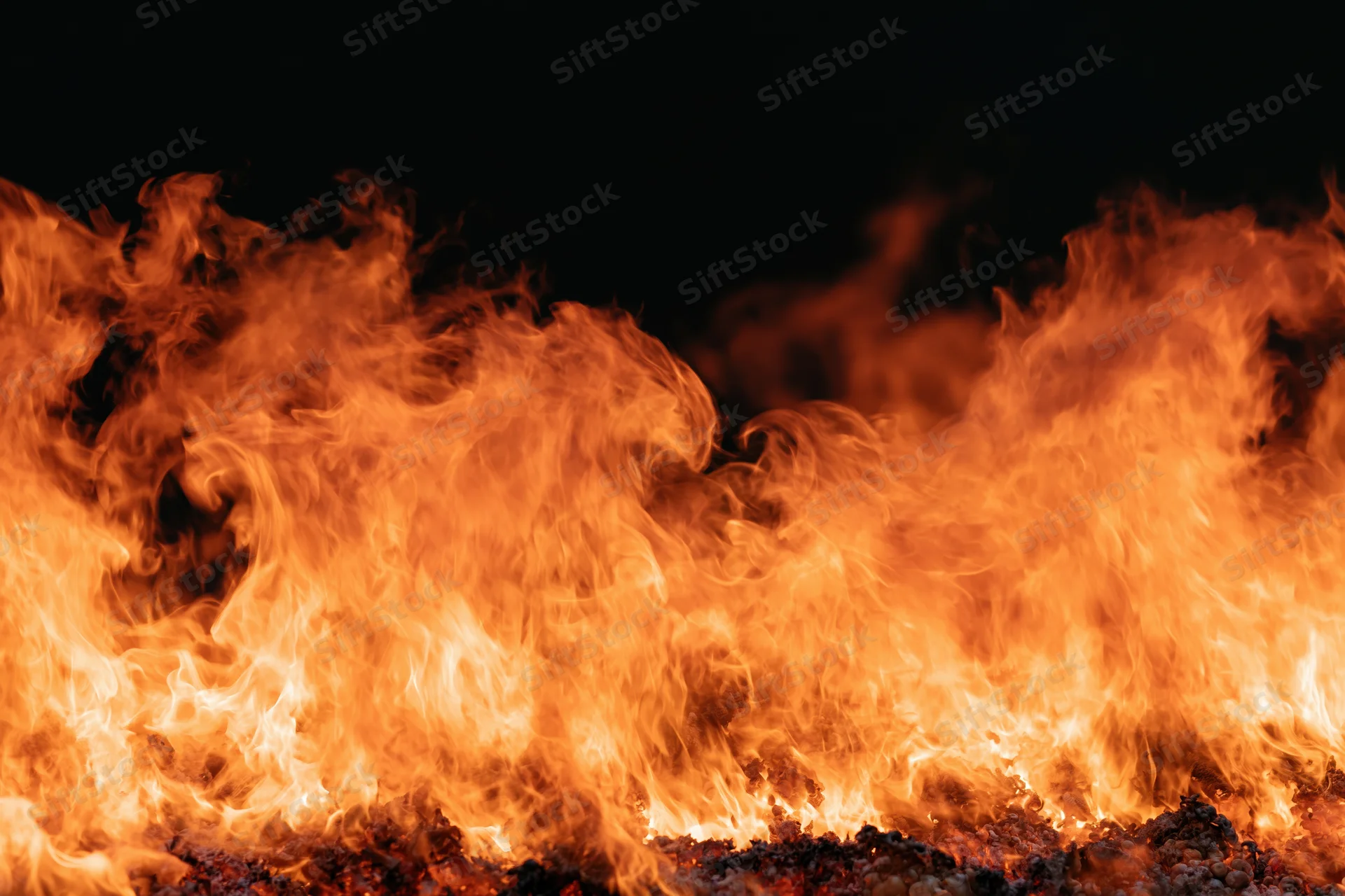 Roaring flames filling the frame against a dark background