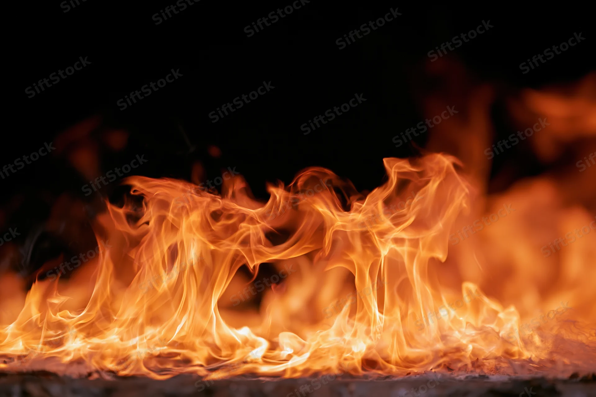 Dynamic fire flames spreading horizontally across frame isolated on black background