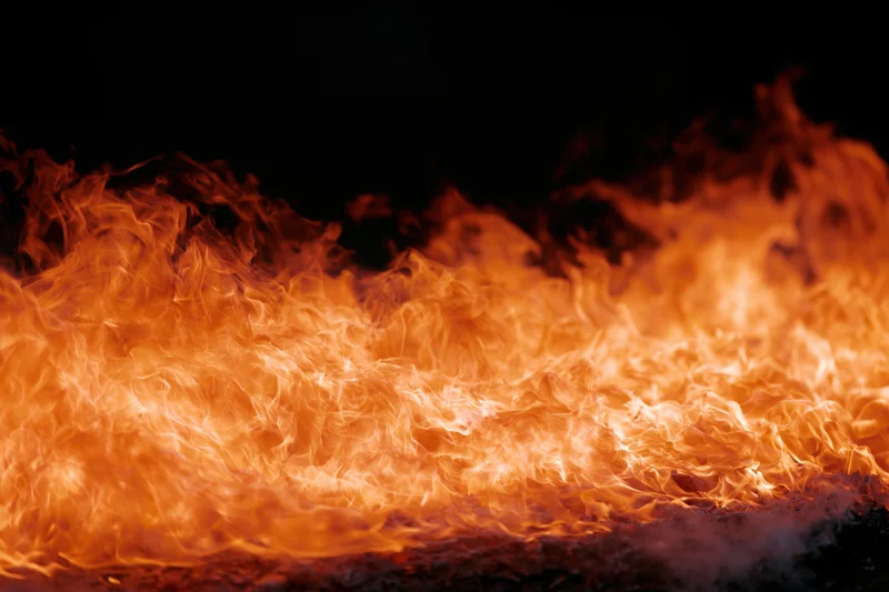 Dynamic fire flames spreading horizontally across frame isolated on black background