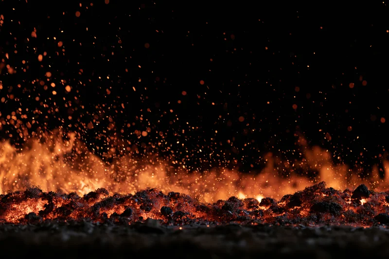 Fire flames and glowing embers burning along the bottom edge against a dark background