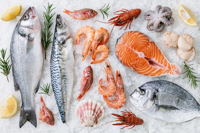 Assorted fresh raw seafood arranged on crushed ice with lemon and rosemary